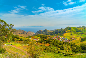 Fototapeta na wymiar Panoramic landscape of Anaga mountains and ocean. Grand Canaria island on the horizon. Blue sky with clouds on a sunny day, Tenerife Canary Islands, Spain