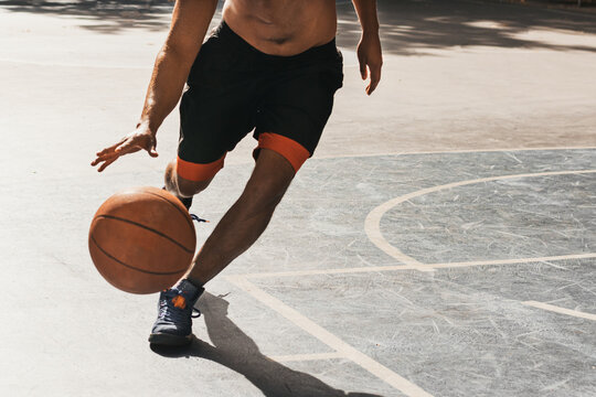 unrecognizable young man playing basketball