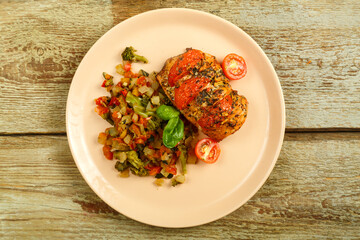 Baked chicken with tomatoes in spices with a side dish of frozen boiled vegetables.