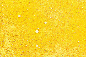 Oil bubbles texture. Cosmetic gold serum background. Abstract bright yellow color oily liquid...