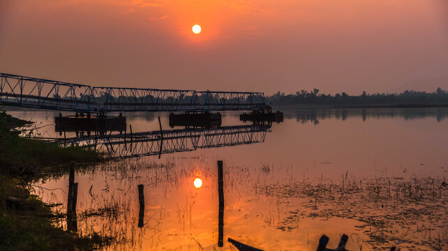The reflection of the pump bridge of water with the sunset of one sun falling on the calm water