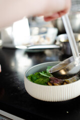 руки повара режут ножом зеленый лук. готовка вьетнамского супа фо бо. вид сверху. свежие натуральные ингридиенты. Национальная еда.