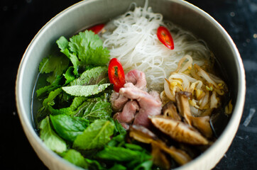cooking pho bo vietnamese soup. serving of soup in a white plate. view from above. Fresh natural ingredients. National food.