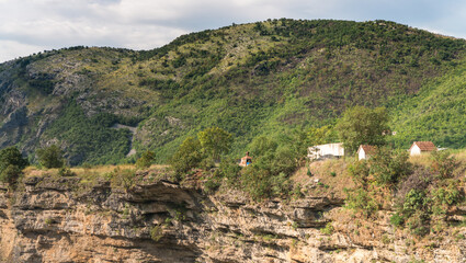 Fototapeta na wymiar Coutryside houses on the edge of a cliff near mountains