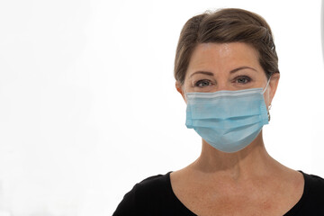 Head shot of a female wearing a face mask because of Covid 19 isolated on white background