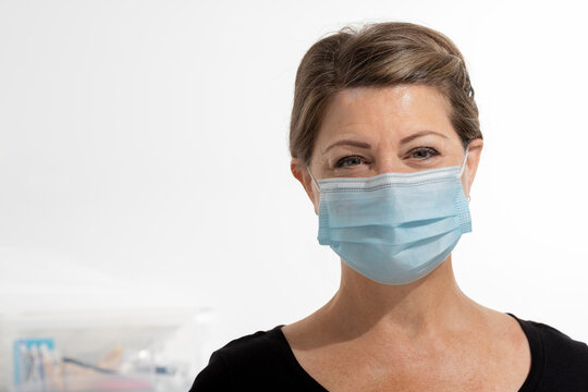 Female Salon Worker Wearing Facial Mask Because Of Covid 19 With Room For Copy To The Left