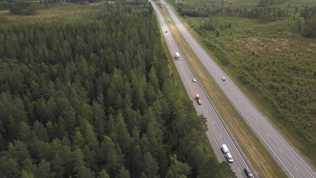 Overview of Heavy Trafficed Highway E4 in Sweden showing cars, trucks and Trailers surrounded by Forest