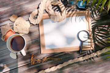 Mock up with empty wooden frame, rope and magnifier, outdoor summer photo