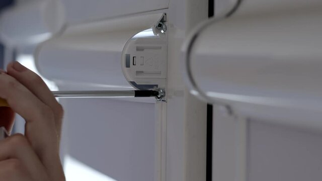 Man installing cassette roller blinds on windows