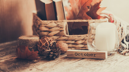 Details of still life on window. Basket of books and autumn leaves on wood background. Autumn mood.