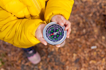 Girls Toddler holding compass in the hands. Children exploring nature in the forest on warm autumn day Kids learning how to use compass. Outdoor recreation and awesome adventures with children in fall © tgordievskaya