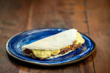 Tapioca with curd cheese and sun meat. Brazilian gastronomy.