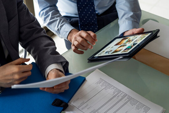 Businessmen holding document and digital tablet