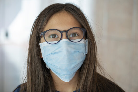 Close up of teenage girl wearing blue surgical mask