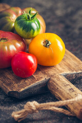 Fresh, ripe multi colored tomatoes on a dark background. Organic food.