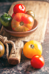 Fresh, ripe multi colored tomatoes on a dark background. Organic food.