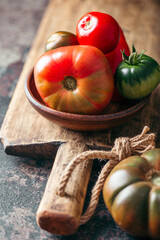 Fresh, ripe multi colored tomatoes on a dark background. Organic food.