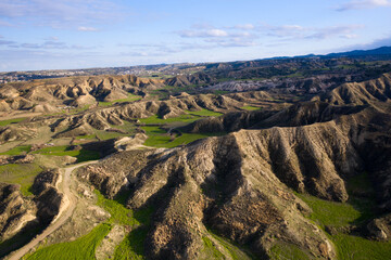 mountain landscapewith green fields in the sunet light with strange uncommon hill formations