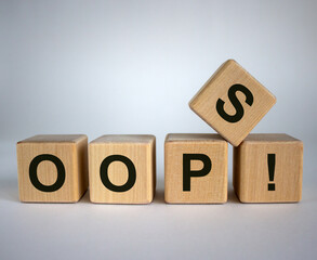 Oops sign on wooden cubes. Beautiful white background, copy space. Concept.