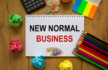 White note with inscription 'new normal business' on beautiful wooden table, colored paper, colored...