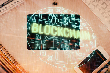 Double exposure of blockchain theme hologram over table with phone. Top view. Crypto technology...