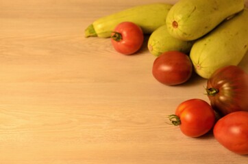 fresh natural zucchini and ripe tomatoes of different varieties from their own beds on a wooden table