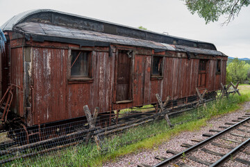 Fototapeta na wymiar Old abandoned red boxcar train car on the railroad tracks in the ghost town of Nevada City Montana