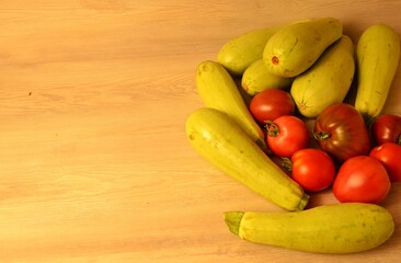 fresh natural zucchini and ripe tomatoes of different varieties from their own beds on a wooden table