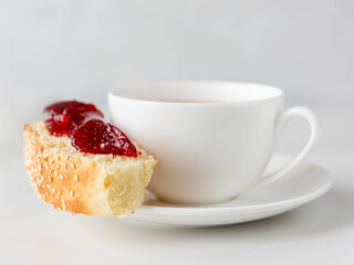 Tea in white cup with roll