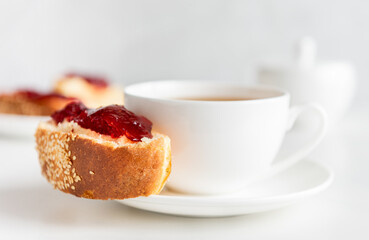 Tea in white cup with roll