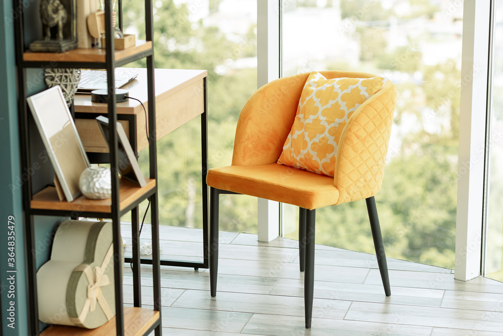 Wall mural home office. by the panoramic window is a wooden table with a laptop, a yellow armchair, and a bookc