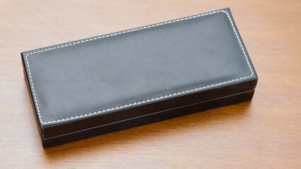 Leather expensive case for a pen on a wooden table