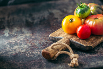 Fresh, ripe multi colored tomatoes on a dark background. Organic food.