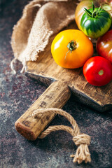 Fresh, ripe multi colored tomatoes on a dark background. Organic food.