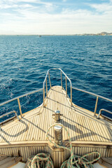 yacht bow view to sea waves and island on horizon. bitt on bow.