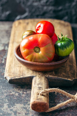 Fresh, ripe multi colored tomatoes on a dark background. Organic food.