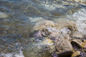 pebble stones on the sea beach, the rolling waves of the sea with foam
