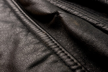 Old vintage genuine soft black leather texture background, top layer with pores and scratches, macro, close-up