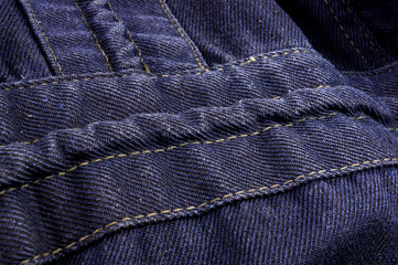 clothing items stonewashed cotton fabric texture with seams, clasps, buttons and rivets, macro