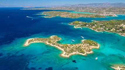 Wandaufkleber Aerial drone photo of Hinitsa bay a popular anchorage crystal clear turquoise sea bay for yachts and sailboats next to Porto Heli, Saronic gulf, Greece © aerial-drone