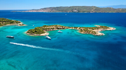 Fototapeta na wymiar Aerial drone photo of Hinitsa bay a popular anchorage crystal clear turquoise sea bay for yachts and sailboats next to Porto Heli, Saronic gulf, Greece
