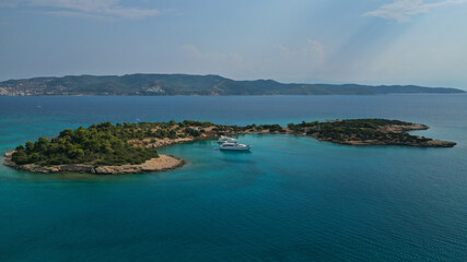 Fototapeta premium Aerial drone photo of Hinitsa bay a popular anchorage crystal clear turquoise sea bay for yachts and sail boats next to Porto Heli, Saronic gulf, Greece