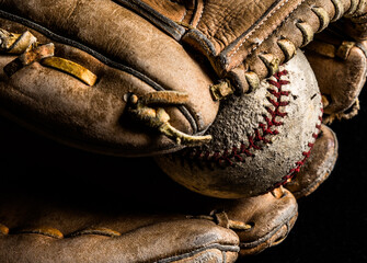 Closeup of old baseball in worn out leather glove