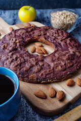 Front view of a delicious homemade fruits bagel in a wooden table. Made of apples, blackberries and almonds using only oats.