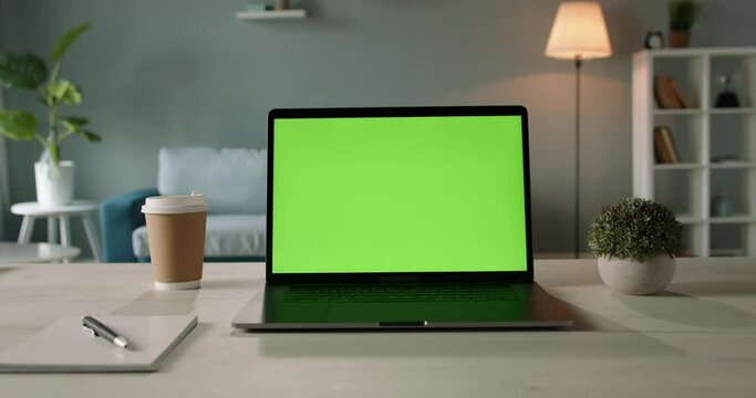 Copy space template - close up shot of modern laptop with chroma key green set up for work in living room at home - technology, design concept 4k zoom shot