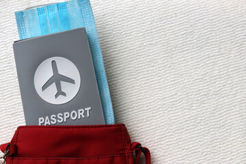 Top view of passport travel and medical mask in red shoulder bag with copy space on white background.  Tourism,holiday and traveling concept in New Normal after Covid-19 / Coronavirus pandemic. 