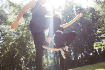 Street fitness, jogging, outdoor workout. Two sporty women running in the park together
