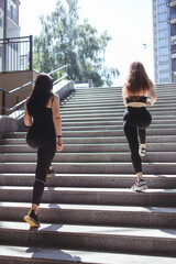 Obraz premium Street fitness, cardio workout, sport in the city. Two sporty women exercising together running outdoors. Endurance, healthy lifestyle and motivation