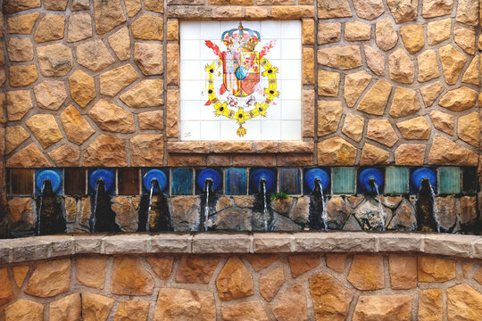 Water fountains with a flag emblem of Alicante in the village of Polop de Marina, Costa Blanca, Spain