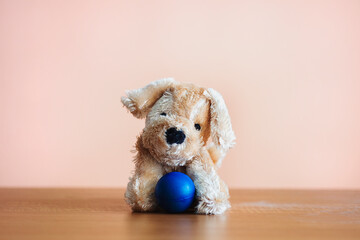 Little toy puppy with a blue ball